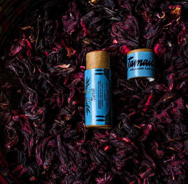 Este bálsamo es nutritivo y reafirmante, gracias al alto contenido en vitamina C de la flor de jamaica. Además, la jamaica es un exfoliante natural, por lo que ayuda a eliminar con suavidad las células muertas de la superficie de los labios, a la vez que deja tus labios hidratados, suaves y brillosos.